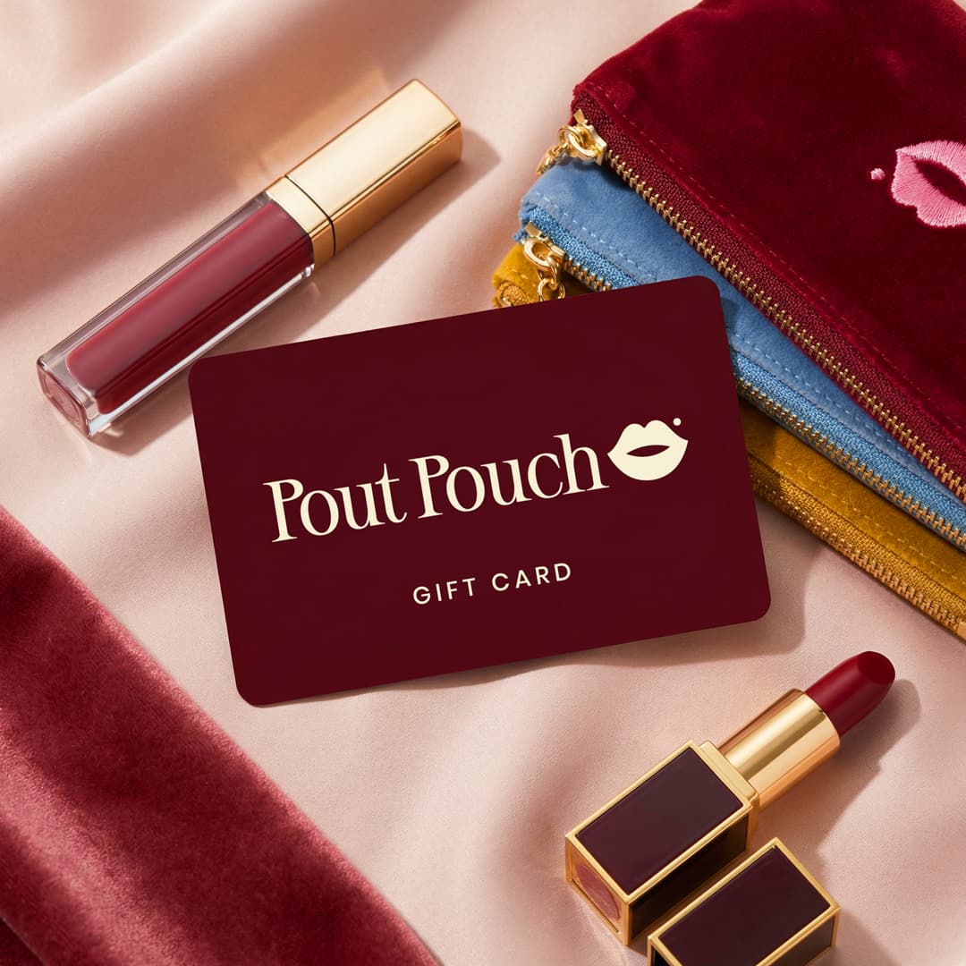 Pout Pouch gift card displayed with velvet makeup pouches and lipstick on a soft satin background