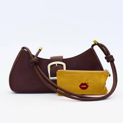 Mustard Pout Pouch velvet makeup pouch placed beside handbag