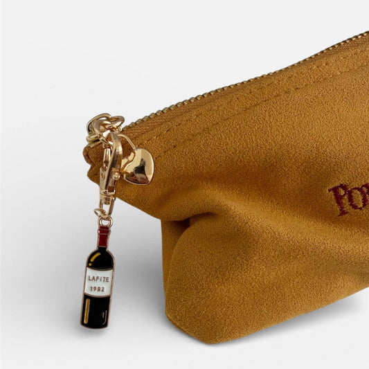 Wine bottle charm clipped onto mustard Pout Pouch zipper